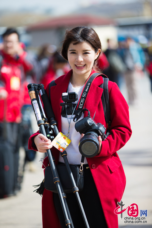 2016年兩會(huì)，人民大會(huì)大堂前，一位笑容燦爛的紅衣女記者正步入大會(huì)堂。中國(guó)網(wǎng) 鄭亮 攝