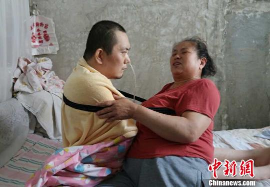 身體日漸衰老的梁青蘭每次幫兒子翻身、坐立，全身的衣物都要濕透一次?！∩忻鱾b 攝