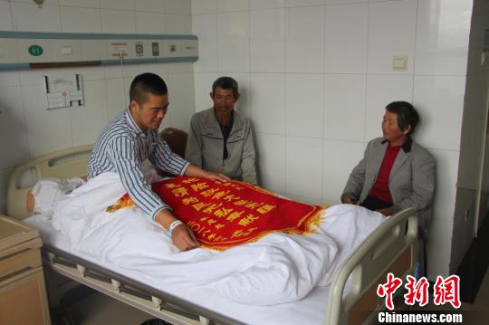 被救的李忠起、張總鳳夫婦看望受傷后的李運(yùn)飛?！⊥粲?攝