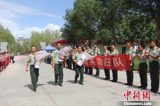 部隊(duì)官兵們迎接出院歸來的李運(yùn)飛(中)和其他消防戰(zhàn)士?！⊥粲?攝