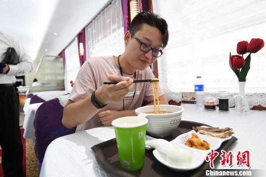 圖為旅客在列車上享用正宗牛肉面?！钇G敏 攝