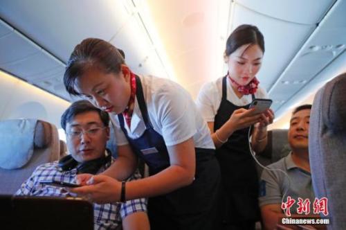 資料圖：乘務(wù)員們?cè)诳团搩?nèi)為旅客調(diào)試機(jī)上上網(wǎng)功能。<a target='_blank' ><p  align=