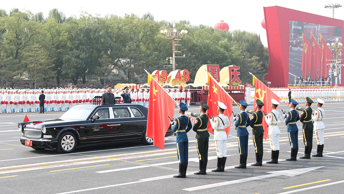 習(xí)近平驅(qū)車行進(jìn)至黨旗、國旗、軍旗前，向旗幟行注目禮