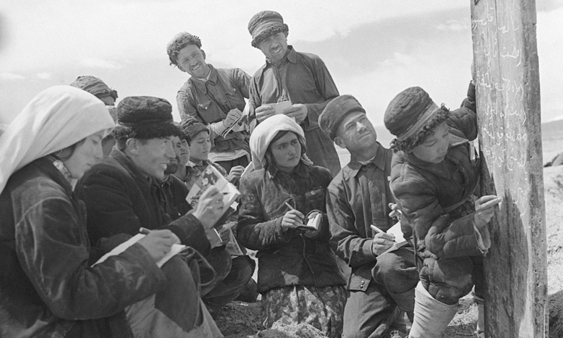 1960年6月，新疆慕士塔格峰下，大人們在小學(xué)生幫助下學(xué)習(xí)文化。新華社記者武純展攝