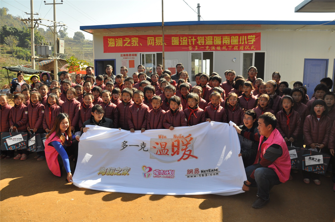 2014年11月20日，“多一克溫暖”公益團(tuán)隊(duì)來到8.3大地震的重災(zāi)區(qū)——云南省昭通市魯?shù)榭h的南筐小學(xué)。越過崎嶇山路，將一批又一批暖心羽絨服送到了師生們的手中，也將社會的關(guān)懷和愛意傳遞給了這些可愛的人。