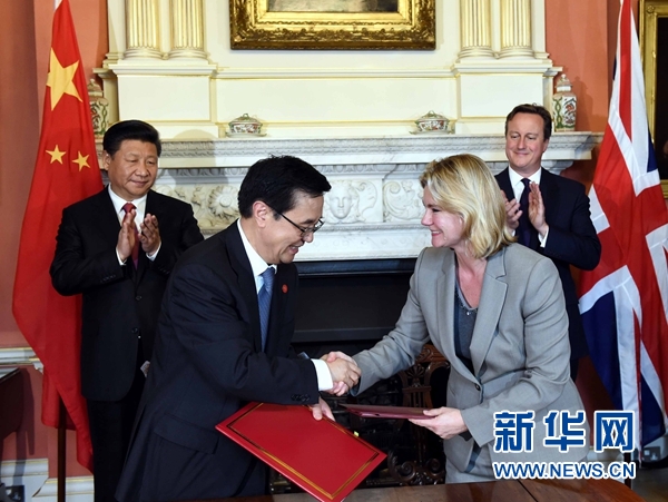 10月21日，國家主席習近平在倫敦唐寧街首相府同英國首相卡梅倫舉行會談。這是會談結束后，兩國領導人共同見證雙邊合作文件的簽署。新華社記者 饒愛民 攝 