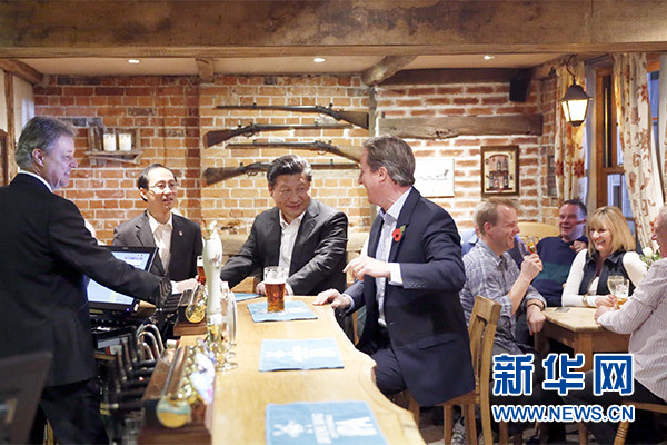 這是會晤結束后，習近平在卡梅倫陪同下乘車前往當?shù)匦℃?zhèn)體驗酒吧文化。新華社記者 鞠鵬 攝