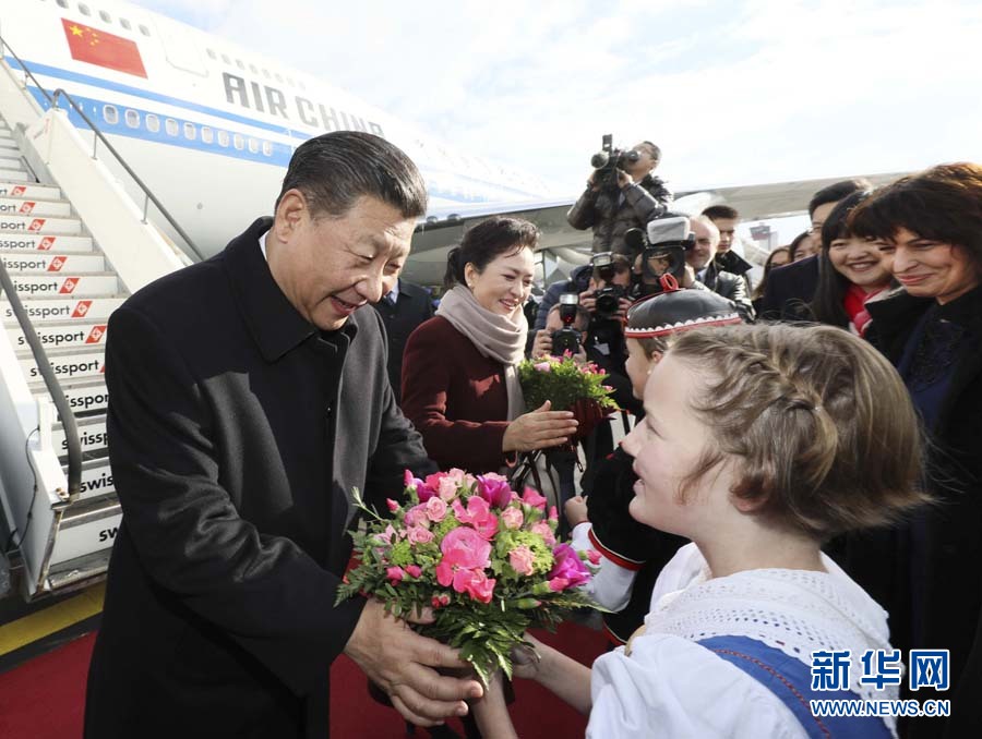 1月15日，國家主席習近平乘專機抵達蘇黎世，開始對瑞士聯(lián)邦進行國事訪問。 這是當?shù)貎和蛄暯胶头蛉伺睇愭芦I上鮮花。 新華社記者蘭紅光 攝